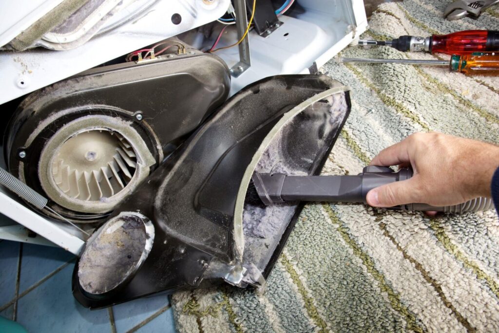 A dryer vent cleaning specialist clears the link from the dryer exhaust system.